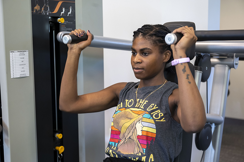 Woman using crest press exercise equipment