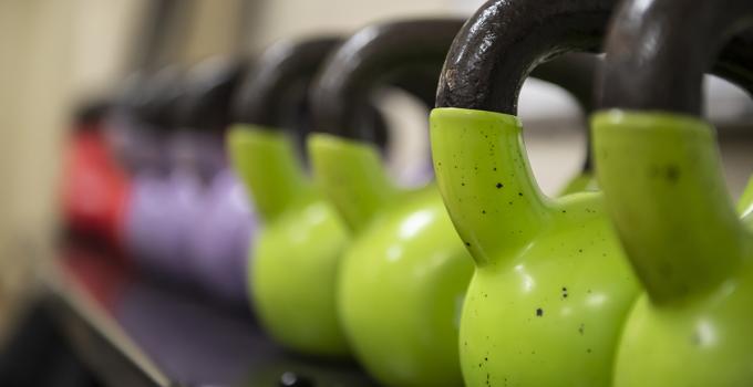 Row of green, purple, and red kettlebells