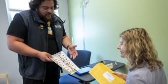 Researcher hands paperwork to a study participant