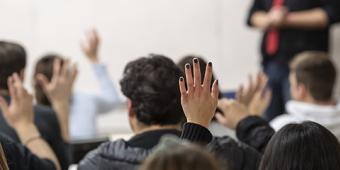 Classroom of students raising their hands